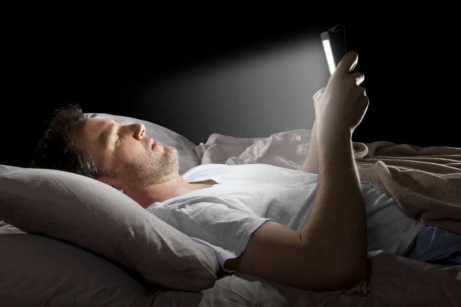 Man in bed using screen Guides